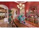 Elegant dining room featuring archway, large table and rich red accent wall at 3592 Grande Tuscany Way, New Smyrna Beach, FL 32168
