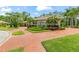 Stately home featuring a circular brick driveway, mature landscaping, and an elegant exterior at 3592 Grande Tuscany Way, New Smyrna Beach, FL 32168