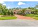 Luxurious home exterior with well-manicured landscaping, a circular brick driveway, and elegant architecture at 3592 Grande Tuscany Way, New Smyrna Beach, FL 32168