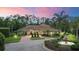 Elegant exterior view with brick driveway, manicured landscaping, mature trees, and a fountain at 3592 Grande Tuscany Way, New Smyrna Beach, FL 32168