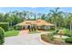 Stunning home featuring a circular driveway, lush landscaping, and a beautiful fountain, creating an inviting curb appeal at 3592 Grande Tuscany Way, New Smyrna Beach, FL 32168