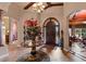 Elegant foyer featuring a decorative table with floral arrangement, tile flooring, and a view of other rooms at 3592 Grande Tuscany Way, New Smyrna Beach, FL 32168