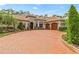 Elegant home featuring a circular brick driveway, manicured landscaping, and a grand entrance at 3592 Grande Tuscany Way, New Smyrna Beach, FL 32168
