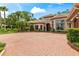 Elegant home showcasing manicured landscaping, a brick driveway, and a stately entrance at 3592 Grande Tuscany Way, New Smyrna Beach, FL 32168
