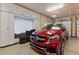 A clean garage includes a luxury car with cabinets, a window, and an electric garage door at 3592 Grande Tuscany Way, New Smyrna Beach, FL 32168