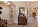 Inviting hallway with a wooden dresser, decorative mirror, and arched doorway at 3592 Grande Tuscany Way, New Smyrna Beach, FL 32168
