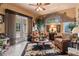A cozy living room features a ceiling fan, patio access, large rug, and comfortable furnishings at 3592 Grande Tuscany Way, New Smyrna Beach, FL 32168