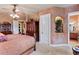 A serene main bedroom offers a ceiling fan, ample closet space, and a glimpse into the en-suite bathroom at 3592 Grande Tuscany Way, New Smyrna Beach, FL 32168