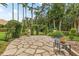 Charming outdoor patio with stone flooring, comfortable seating, and lush landscaping at 3592 Grande Tuscany Way, New Smyrna Beach, FL 32168