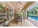 Covered outdoor patio with ceiling fans and an outdoor dining set at 3592 Grande Tuscany Way, New Smyrna Beach, FL 32168