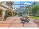 This screened in-ground pool features brick pavers and lounge chairs at 3592 Grande Tuscany Way, New Smyrna Beach, FL 32168