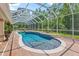 This in-ground pool is surrounded by a screened enclosure and lush landscaping at 3592 Grande Tuscany Way, New Smyrna Beach, FL 32168