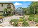 Backyard view of a screened pool enclosure complemented by lush landscaping and a stone patio at 3592 Grande Tuscany Way, New Smyrna Beach, FL 32168