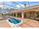 This screened in-ground pool features brick pavers and lounge chairs at 3592 Grande Tuscany Way, New Smyrna Beach, FL 32168