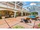 This screened patio includes an outdoor kitchen, lounge chairs, and dining areas at 3592 Grande Tuscany Way, New Smyrna Beach, FL 32168