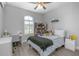 Cozy bedroom with neutral colors, a ceiling fan, plantation shutters, and a comfortable bed at 413 Last Tree Dr, Deland, FL 32720