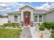 Charming home exterior featuring a decorative red front door and well-maintained landscaping at 413 Last Tree Dr, Deland, FL 32720
