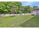 A spacious back yard with a fence, trees, a shed, a table and chairs on an area near the house at 414 Lancaster Ave, Orange City, FL 32763