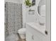 Bright bathroom featuring a floral shower curtain, modern vanity, and decorative wall accents at 414 Lancaster Ave, Orange City, FL 32763