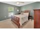 Cozy bedroom with green walls, ceiling fan, and comfortable wooden bed at 414 Lancaster Ave, Orange City, FL 32763