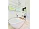 Bright bathroom featuring a soaking tub, chandelier, TV and shiplap walls at 417 S Palmetto Ave, Daytona Beach, FL 32114