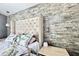 Bedroom features stone wall, tufted headboard, and stylish pendant lighting at 417 S Palmetto Ave, Daytona Beach, FL 32114