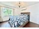 Comfortable bedroom with large window, floral bedding, accent lighting and air conditioning unit at 417 S Palmetto Ave, Daytona Beach, FL 32114