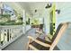 Relaxing front porch featuring rocking chairs, porch swing, and lime green door at 417 S Palmetto Ave, Daytona Beach, FL 32114