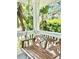 Front porch swing with a view of the lush tropical plants in the yard at 417 S Palmetto Ave, Daytona Beach, FL 32114