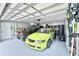Organized garage featuring racing car, golf cart, cabinets, and green pegboard wall mounted tools at 417 S Palmetto Ave, Daytona Beach, FL 32114