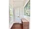 Hallway featuring wooden floors and a leopard painting with a door featuring a circular design at 417 S Palmetto Ave, Daytona Beach, FL 32114