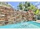 Close up of a stone waterfall flowing into the pool at 417 S Palmetto Ave, Daytona Beach, FL 32114