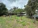 Green backyard features a charming home, white porch, and a grassy area, perfect for outdoor living at 43721 State Road 19, Altoona, FL 32702