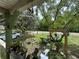 Tranquil view from the porch, featuring a cozy seating area and shade trees at 43721 State Road 19, Altoona, FL 32702