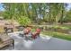 Picturesque backyard with a stone patio, grill, cozy seating, and lush landscaping at 535 Black Ironwood Dr, Deland, FL 32724