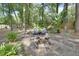 Backyard fire pit with comfortable blue Adirondack chairs surrounded by lush greenery and trees at 535 Black Ironwood Dr, Deland, FL 32724