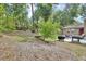Lush backyard showcasing mature trees and a patio with grill and seating, perfect for outdoor enjoyment at 535 Black Ironwood Dr, Deland, FL 32724