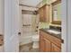 Well-lit bathroom with shower and tub, tiled walls, updated vanity, and neutral color scheme at 535 Black Ironwood Dr, Deland, FL 32724