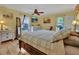 Comfortable bedroom with ceiling fan, wood floors, and windows letting in natural light at 535 Black Ironwood Dr, Deland, FL 32724