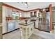 Bright kitchen featuring stainless steel appliances, white cabinets, an island, and stylish lighting at 535 Black Ironwood Dr, Deland, FL 32724