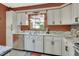 Bright kitchen featuring granite countertops, white cabinetry, stainless steel dishwasher, and a double basin sink at 535 Black Ironwood Dr, Deland, FL 32724
