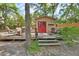 Charming backyard shed with a wooden deck and cozy seating amidst lush greenery at 535 Black Ironwood Dr, Deland, FL 32724