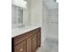 Bathroom featuring dark cabinets, light countertops, a mirror, and a walk-in shower at 600 N Boundary Ave # 110A, Deland, FL 32720