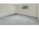 Neutral bedroom featuring a large window, light gray carpet, and ample natural light at 600 N Boundary Ave # 110A, Deland, FL 32720