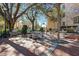 Beautiful courtyard featuring stone picnic tables, benches, large trees, and brick pavers at 600 N Boundary Ave # 110A, Deland, FL 32720