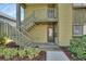 Inviting exterior view of the condo featuring a quaint walkway and staircase to upper level unit at 600 N Boundary Ave # 110A, Deland, FL 32720