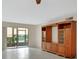 Bright living room featuring tile floors, built-in shelving, and sliding glass door to the porch at 600 N Boundary Ave # 110A, Deland, FL 32720