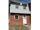 Charming two-story townhome with brick and gray siding, complemented by well-maintained landscaping at 621 W Indiana Ave # 13, Deland, FL 32720