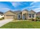 Charming one-story home featuring a well-manicured lawn and a two-car garage, exuding curb appeal at 6871 Forkmead Ln, Port Orange, FL 32128