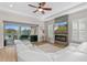 Cozy living room with a stone fireplace, large windows, and access to the backyard at 6871 Forkmead Ln, Port Orange, FL 32128